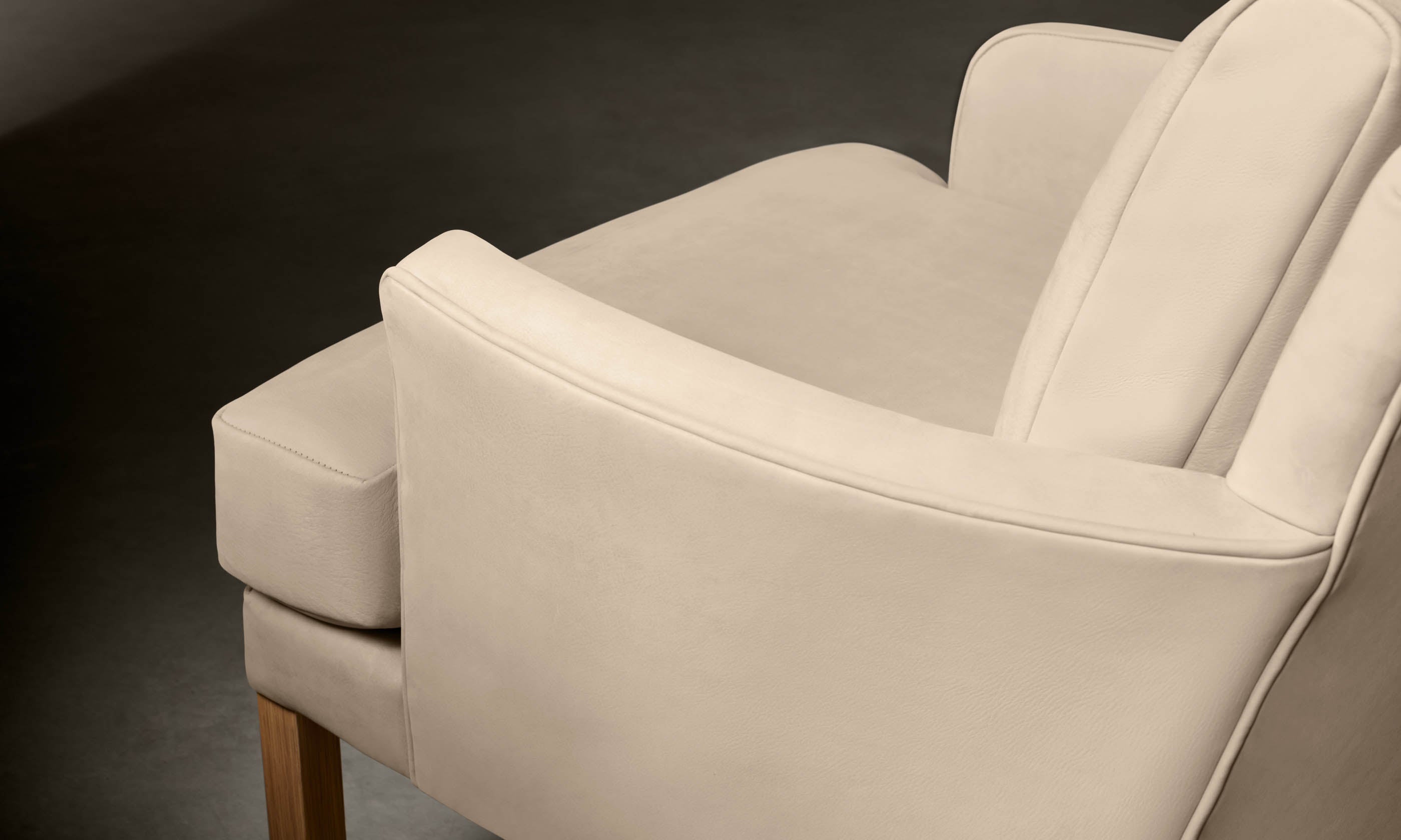 kaye leather accent chair in grey nubuck leather with wooden legs, close up