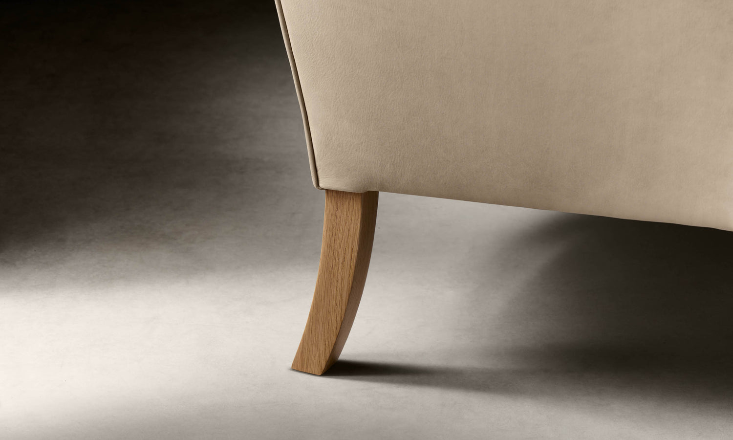 kaye leather accent chair in grey nubuck leather with wooden legs, leg close up