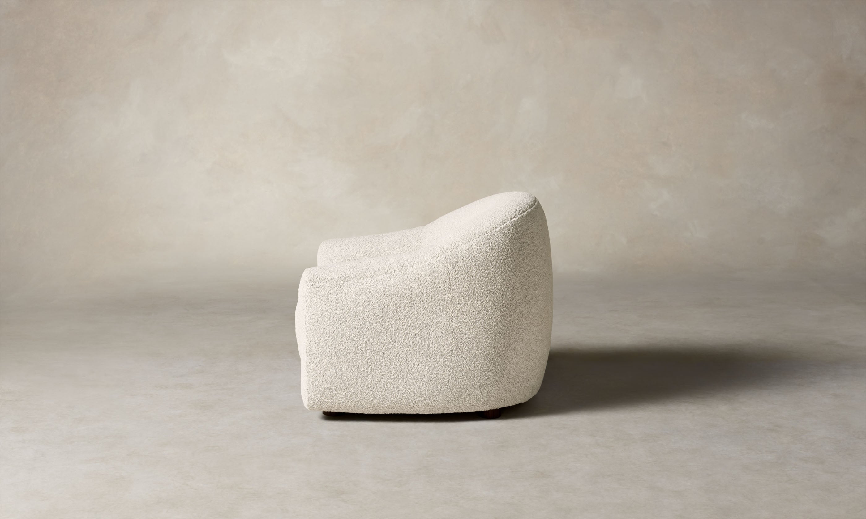 oliver accent chair in white boucle with curved back, side view