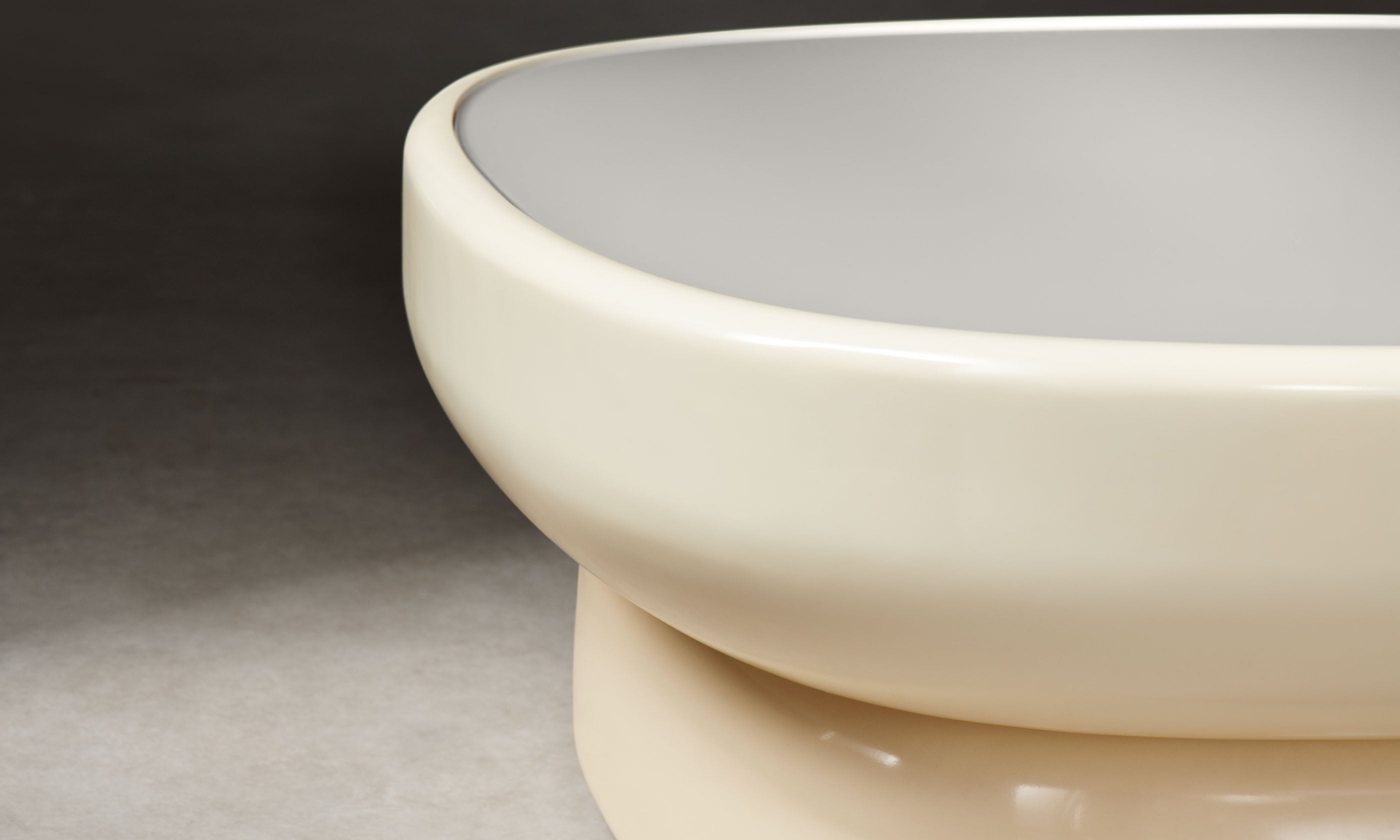 emile oval glass coffee table with lacquered beige base and white opaque glass top in art deco style, close up