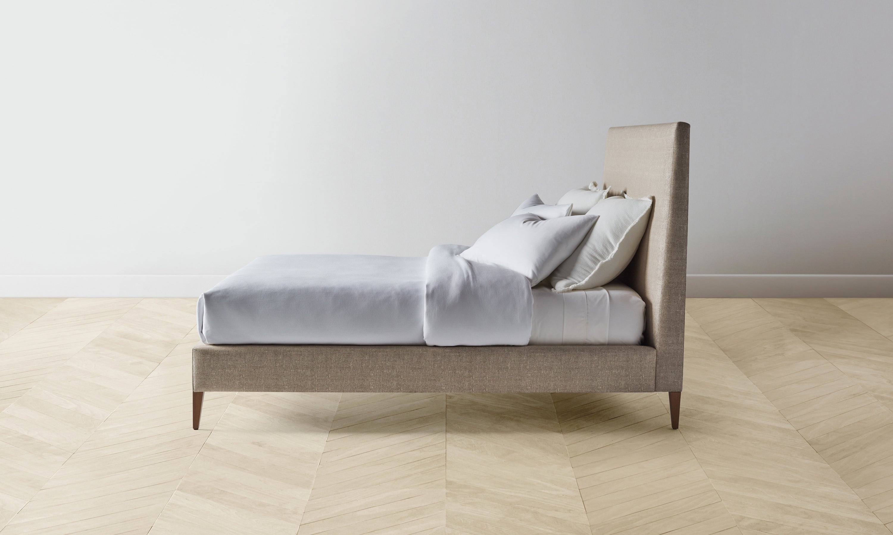 essex bed with upholstered headboard and frame in beige basketweave fabric with wooden legs - side view