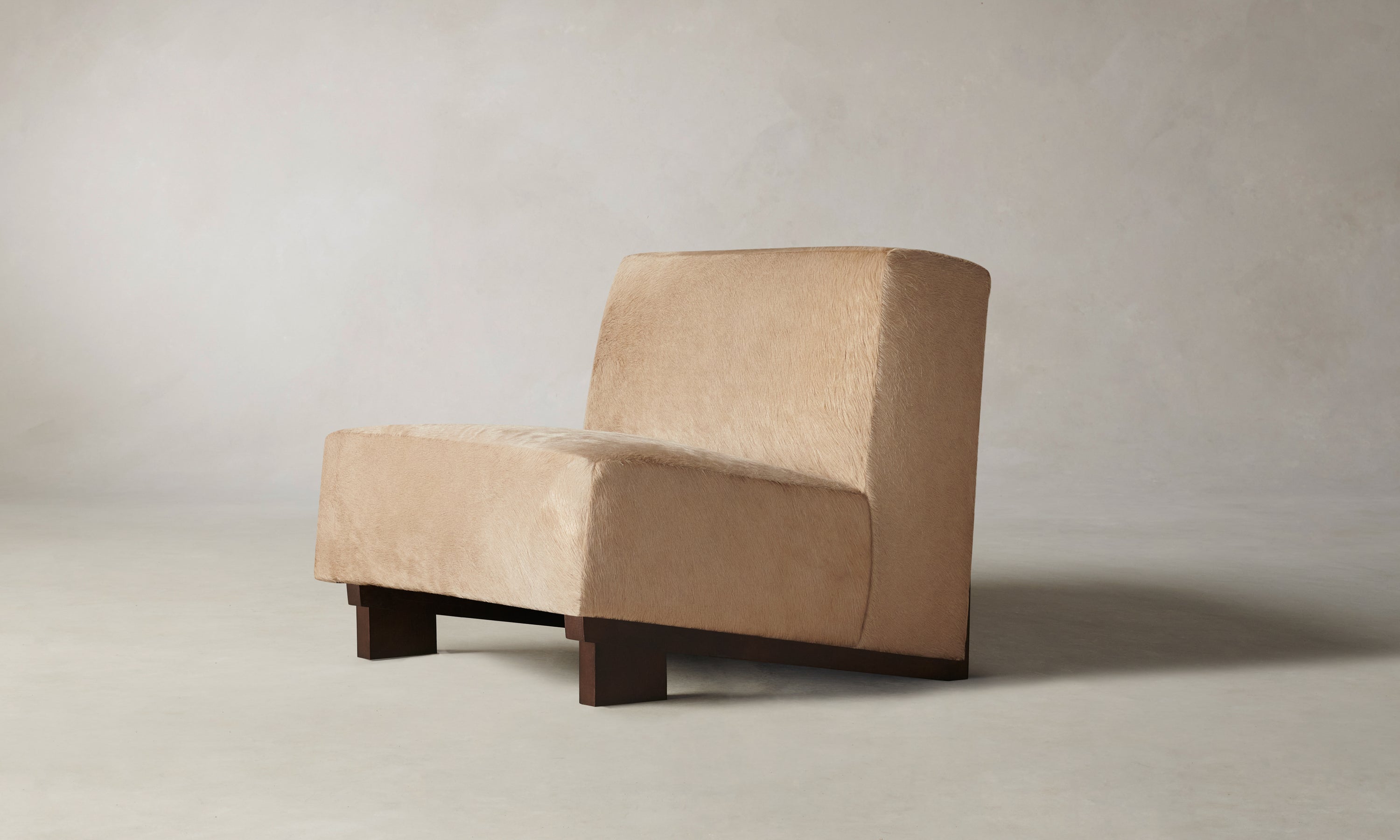 remsen accent chair upholstered in brown pony hair with wooden legs and geometric design