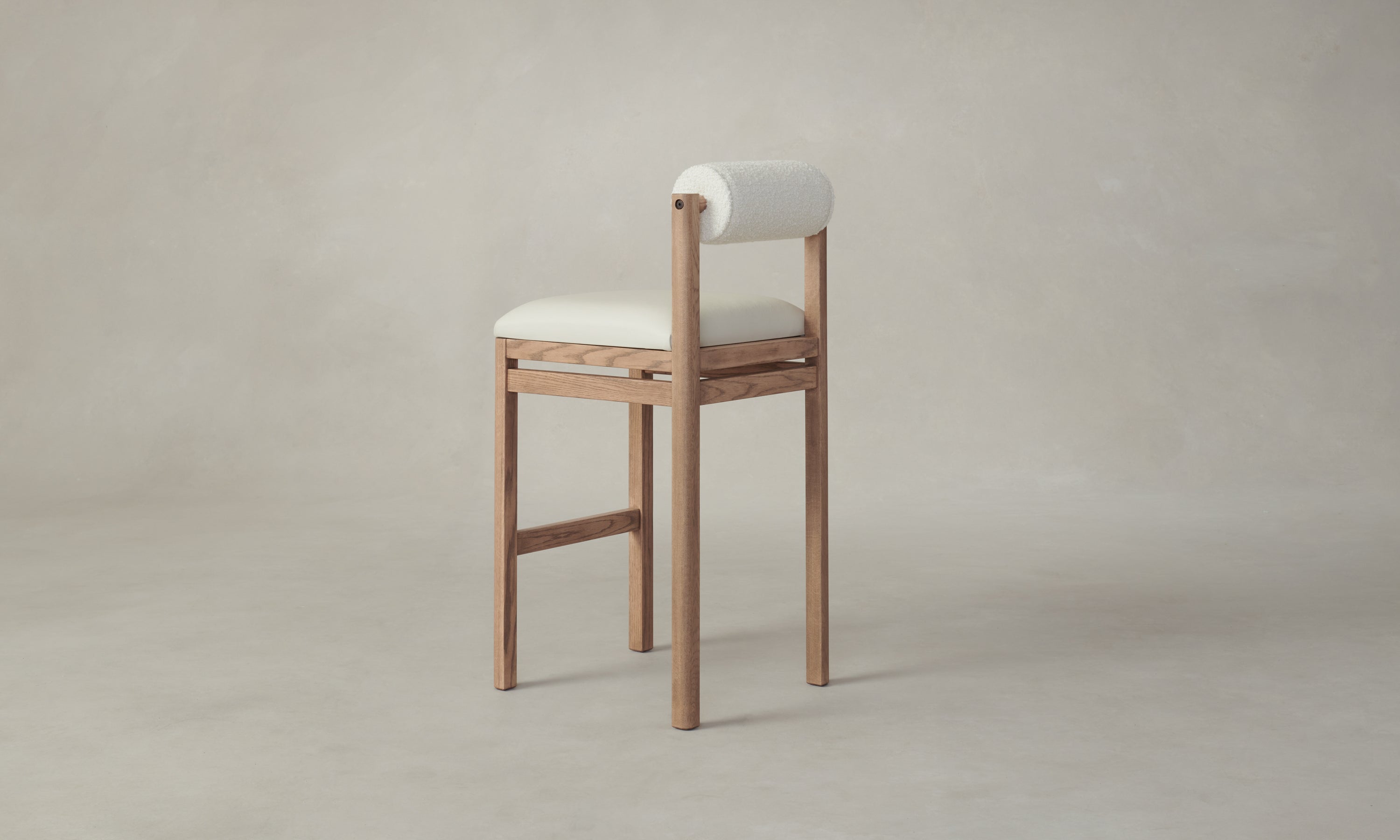 thayer wood barstool in oak with white leather seat and boucle bolster back, angle view
