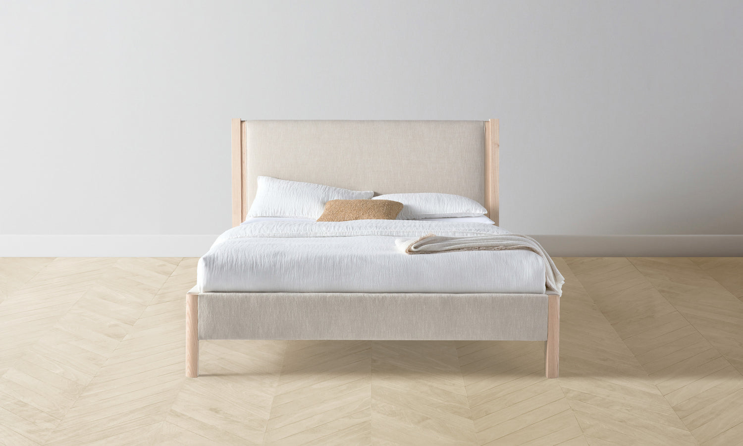 thomson upholstered bed in beige linen with ash wood legs - front view