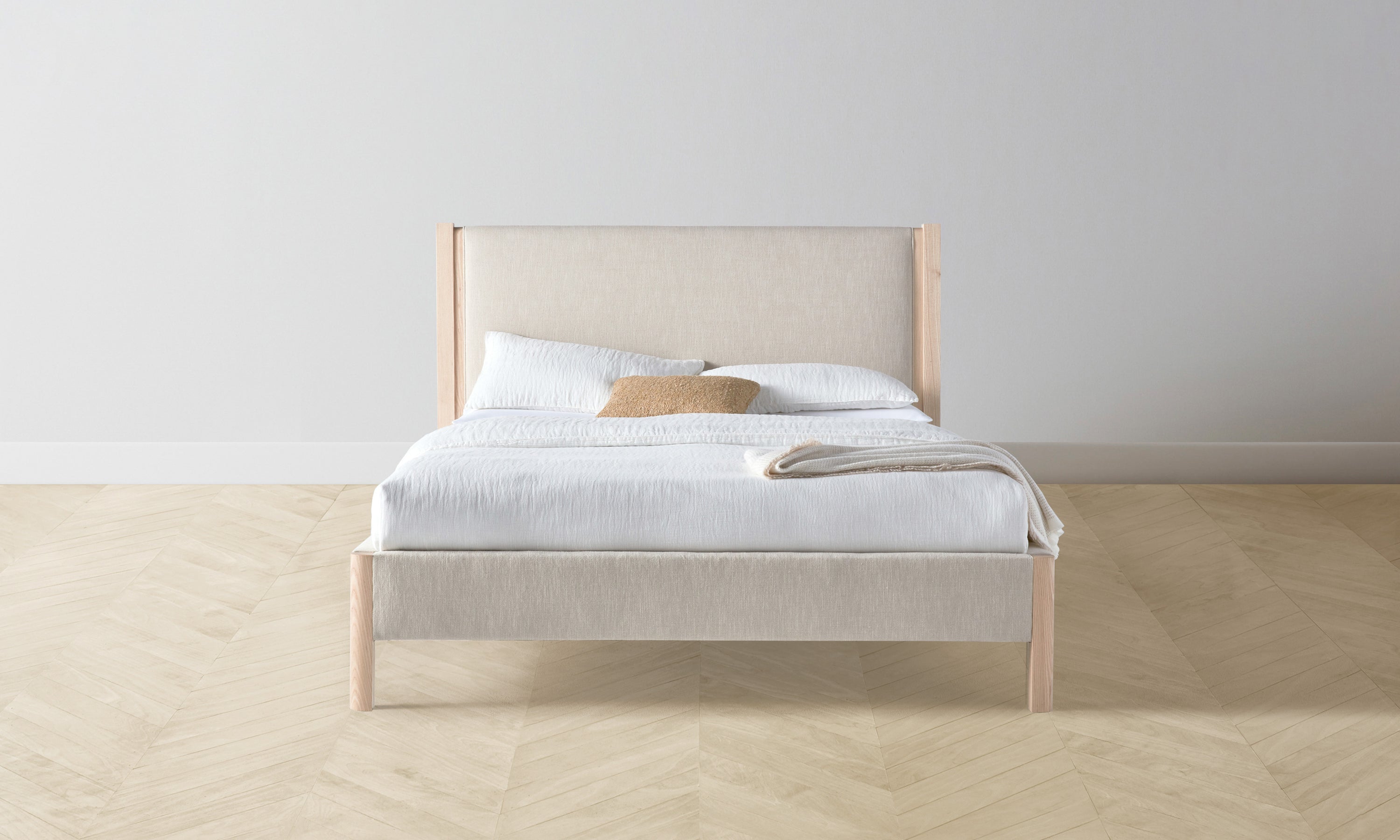 thomson upholstered bed in beige linen with ash wood legs - front view